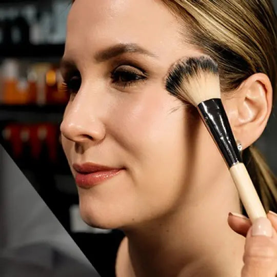 Powder brush sweeping across a cheek